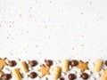 Sweet festive pastry border with chocolate, waffles, cookies, marshmallows and pastry topping on a white background