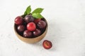 Sweet fresh delicious red plums on bowl white wood table summer fruits