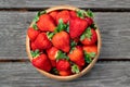 Sweet fresh juicy organic ripe strawberries in wooden bowl on wooden surface outdoors Royalty Free Stock Photo