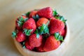 Sweet fresh juicy organic ripe strawberries in wooden bowl on wooden table surface at home Royalty Free Stock Photo