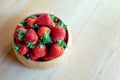 Sweet fresh juicy organic ripe strawberries in wooden bowl on wooden table surface at home Royalty Free Stock Photo