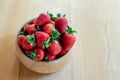 Sweet fresh juicy organic ripe strawberries in wooden bowl on wooden table surface at home Royalty Free Stock Photo