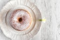 Sweet fried donut covered with sugar on plate