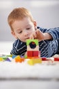 Sweet gingerish boy building tower at home Royalty Free Stock Photo
