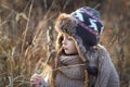 Sweet girl in a cap with the deer in autumn in a field of dry grass Royalty Free Stock Photo