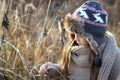 Sweet girl in a cap with the deer in autumn in a field of dry grass Royalty Free Stock Photo