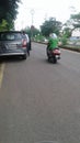 A sweet girl in green dress driving motorcycle