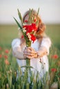 Sweet  girl holding  red poppy flowers in hands. Close up photo Royalty Free Stock Photo