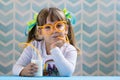 Sweet girl kid drinking milk with funny glasses straw.