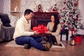 Sweet girl making a surprise to her boyfriend with a gift box on christmas day Royalty Free Stock Photo