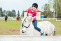 A sweet girl riding a white horse, an athlete engaged in equestrian sports, a girl hugs and kisses a horse. Royalty Free Stock Photo
