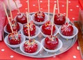 Sweet glazed red toffee candy apples on sticks for sale on farmer market or country fair. Thanksgiving and Halloween homemade red Royalty Free Stock Photo