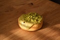 Sweet green pistachio donut with pistachio pieces and drizzled icing Royalty Free Stock Photo