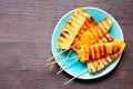 Grilled summer pineapple wedges over dark wood