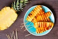 Grilled summer pineapple wedges, top view table scene over dark wood