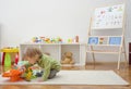 Sweet happy child boy having fun playing with cars and many colorful toys, on the floor, at home Royalty Free Stock Photo