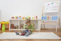 Sweet happy child boy having fun playing with cars and many colorful toys, on the floor, at home Royalty Free Stock Photo