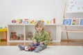 Sweet happy child boy having fun playing with cars and many colorful toys, on the floor, at home Royalty Free Stock Photo