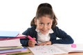 Sweet happy latin child sitting on desk doing homework and smiling Royalty Free Stock Photo