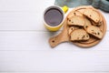 Sweet hard chuck crackers with raisins and cup of tea on white wooden table, flat lay. Space for text Royalty Free Stock Photo