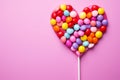 Sweet harmony rainbow heart candies arranged on a pink background