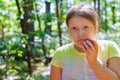 Child girl eating an red apple in a park in nature. Royalty Free Stock Photo