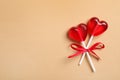 Sweet heart shaped lollipops on beige background, top view with space for text. Valentine`s day celebration Royalty Free Stock Photo