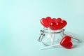 Sweet heart shaped lollipops in glass jar on light blue background, space for text. Valentine`s day celebration Royalty Free Stock Photo