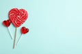 Sweet heart shaped lollipops on light blue background, flat lay with space for text. Valentine`s day celebration Royalty Free Stock Photo