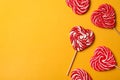 Sweet heart shaped lollipops on orange background, flat lay with space for text. Valentine`s day celebration Royalty Free Stock Photo