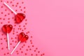 Sweet heart shaped lollipops and sprinkles on pink background, flat lay with space for text. Valentine`s day celebration Royalty Free Stock Photo