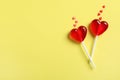 Sweet heart shaped lollipops and sprinkles on yellow background, flat lay with space for text. Valentine`s day celebration Royalty Free Stock Photo