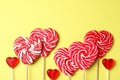 Sweet heart shaped lollipops on yellow background, flat lay with space for text. Valentine`s day celebration Royalty Free Stock Photo