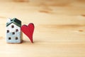 Sweet home concept, mini house symbol and red heart on wooden background
