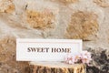 Sweet home sign on a wood trunk. Stone wall background Royalty Free Stock Photo