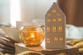 Sweet Home. Still life details in home interior of living room. Sweaters and candle, autumn decor on the books.