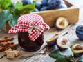 Sweet homemade plum jam and fruits on table.