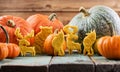 Sweet homemade pumpkin cookies shaped like animals: bear, moose, wolf decorated with raw pumpkins on blue wooden background Royalty Free Stock Photo