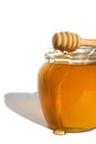 Sweet honey flows over a glass jar. White isolated background. Royalty Free Stock Photo