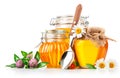 Sweet honey in glass jar with spoon and flowers