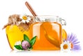 Sweet honey in glass jar with spoon and flowers