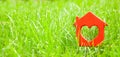 Sweet house in the grass. Concept of eco house, cottage. Symbol of house with heart on green lawn. Copy space for text Royalty Free Stock Photo