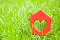 Sweet house in the grass. Concept of eco house, cottage. Symbol of house with heart on summer lawn