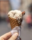 Sweet ice cream in waffle cone in a hand close up. Tiramisu-flavored ice cream.