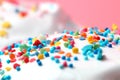 Sweet icing with colored sugar balls, stars, Pink background, copy space, close-up. Christmas or birthday concept, festive mood Royalty Free Stock Photo