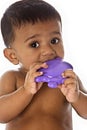 Sweet Indian baby chewing on toy