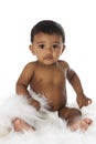 Sweet Indian baby sitting on white fur