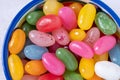 Sweet jelly beans in a ceramic bowl on a white background. Colorful candy with mixed fruit flavor. Top view, close-up. Royalty Free Stock Photo