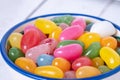 Sweet jelly beans in a ceramic bowl on a white wooden background with copy space. Colorful candy with mixed fruit flavor. Royalty Free Stock Photo