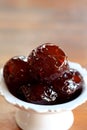 Sweet Jujube or Chinese red date in syrup in white Thai style cup on wood table and space for write wording